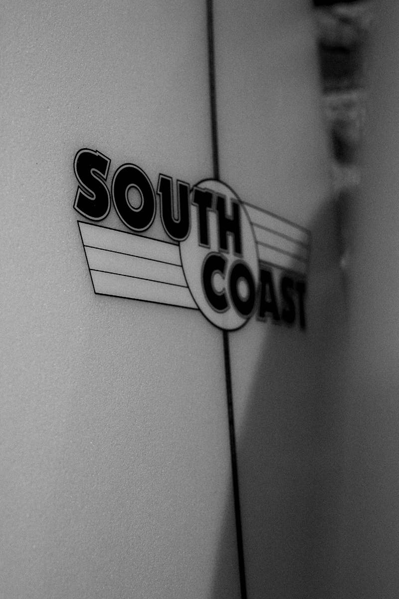 Close-up of the South Coast logo on a surfboard, emphasizing coastal style and surf culture.